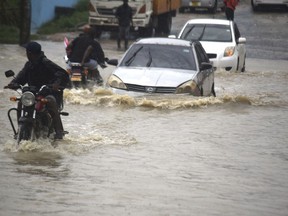 Motorists wade through a flooded road in Mombasa town after a heavy downpour on Friday Nov.3, 2023. Most of the roads remained impassable due to poor drainage system within the town.