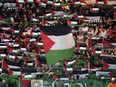 Celtic fans in the stands wave Palestinian flags