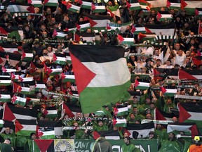 Celtic fans in the stands wave Palestinian flags