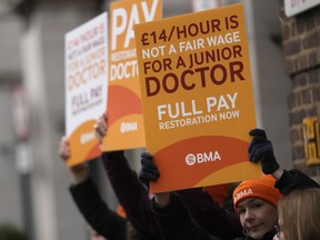 FILE - Junior doctors hold placards on a picket line outside St Mary's Hospital in London, Tuesday, March 14, 2023. Britain's government reached a deal with senior doctors in England that could potentially end a series of disruptive strikes, officials said Monday, Nov. 27, 2023.