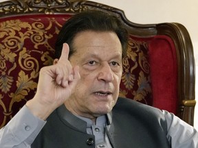 FILE - Pakistan's former Prime Minister Imran Khan gestures during talk with reporters regarding the current political situation and the ongoing cases against him at his residence, in Lahore, Pakistan, on Aug. 3, 2023. A Pakistani court Tuesday Nov. 28, 2023 ordered a public trial in prison of former Prime Minister Imran Khan on charges of revealing official secrets, his lawyer said.