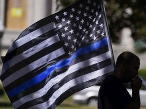 FILE - In this Aug. 30, 2020 file photo, an unidentified man participates in a Blue Lives Matter rally in Kenosha, Wis. A federal court has ruled that a Pennsylvania township cannot ban an American flag with a thin blue line from being publicly displayed, or prohibit use of its image by township employees, saying it is a violation of the First Amendment.