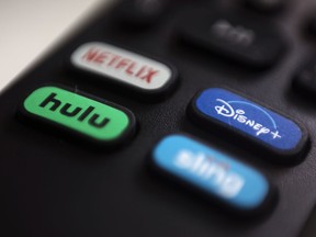 FILE - The logos for streaming services Netflix, Hulu, Disney Plus and Sling TV are pictured on a remote control on Aug. 13, 2020, in Portland, Ore. Walt Disney Co. said it will acquire a 33% stake in Hulu from Comcast for approximately $8.6 billion, a deal that will give Disney undisputed control of the streaming service.