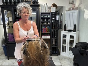 FILE - Christine Geiger cuts a customer's hair at her salon, July 12, 2023, in Traverse City, Mich. The hair salon is facing a discrimination charge from the state's Department of Civil Rights after Geiger posted on social media earlier this year that anyone identifying as other than a man or a woman is not welcome at her business.