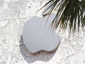 FILE - The Apple logo is displayed over their store, Sept. 19, 2023, in Miami Beach, Fla. Apple has agreed to pay $25 million to settle allegations that it engaged in a pattern of discriminatory hiring practices when filling some of its jobs during 2018 and 2019. The deal announced Thursday, Nov. 9, resolved a lengthy investigation by the U.S. Department of Justice into alleged violations of the Immigration and Nationality Act.