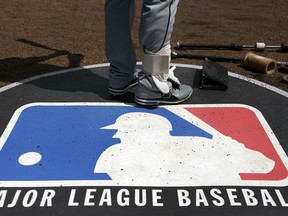FILE - A baseball player stands on the Major League Baseball, MLB, logo on April 24, 2013, in Chicago. Police say the Detroit Tigers complex in the Dominican Republic was targeted Wednesday, Oct. 18, 2023, in the latest robbery of a Major League Baseball facility in the country.