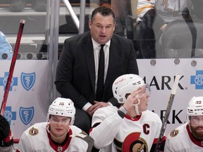 Ottawa Senators head coach D.J. Smith, top, stands behind his bench during the third period of an NHL hockey game against the Pittsburgh Penguins in Pittsburgh, Saturday, Oct. 28, 2023. Smith says his team will just have to block out the noise moving forward.