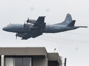 A 2019 file photo of a CP-140 Aurora airplane doing a flyby over Stanley Park in Vancouver.