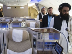 Afghan Taliban Envoy to the United Arab Emirates Badruddin Haqqani, far right, walks through an Emirates A380's business class on display at the Dubai Air Show in Dubai, United Arab Emirates, Monday, Nov. 13, 2023. The biennial Dubai Air Show opened Monday as airlines are poised to make major aircraft purchases after rebounding from the groundings of the coronavirus pandemic, even as Israel's war with Hamas clouds regional security.