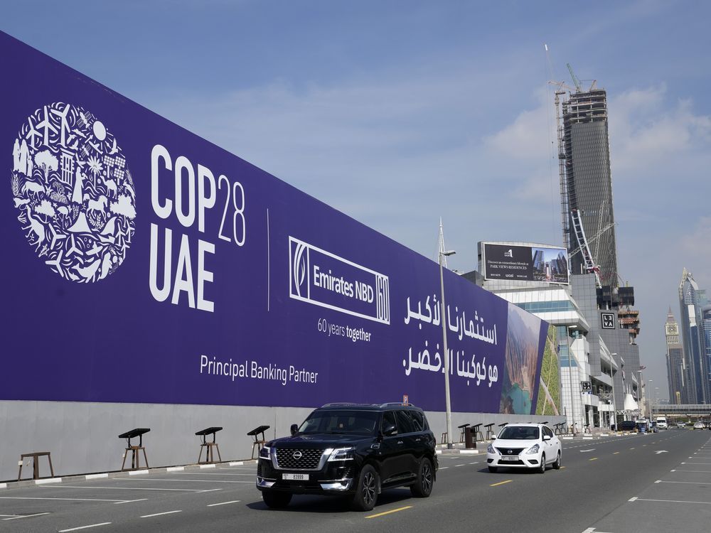 Cars pass by a billboard advertising COP28 at Sheikh Zayed highway in Dubai, United Arab Emirates, Monday, Nov. 27, 2023. 