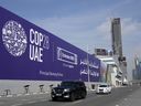 Cars pass by a billboard advertising COP28 at Sheikh Zayed highway in Dubai, United Arab Emirates, Monday, Nov. 27, 2023.