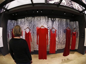 Indigenous groups and Manitoba RCMP are partnering to implement some recommendations in the final report from the National Inquiry into Missing and Murdered Indigenous Women and Girls. A woman looks at the Red Dress-From Sorrow To Strength display in honour of Missing and Murdered Indigenous Women and Girls, part of the Indigenous Exhibit, at the Canadian Museum for Human Rights in Winnipeg Thursday, June 21, 2018.