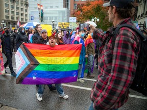 A group of activists joined together for the Protect Trans Kids (again) protest to show support for anti-LGBT hate, rallying together at the Human Rights Monument on Elgin and marching to Parliament Hill, in Ottawa, Oct. 21, 2023. A small group of counter protesters voiced their opinions on Wellington Street nearby including Chris Dacey (right).