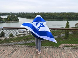 A child wrapped in an Israeli flag looks over a river during the "Walk for peace in Israel" in support of the people of Israel, in Belgrade on Oct. 15, 2023, following the Oct. 7 Hamas attacks in Israel.