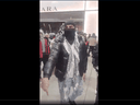 An unnamed protester at the Toronto Eaton Centre Sunday gestures while facing Toronto police officers.