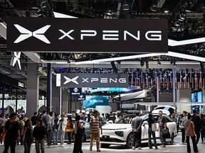 People visit a booth for the Chinese EV giant XPeng at the Shanghai International Automobile Industry Exhibition on April 19, 2023.