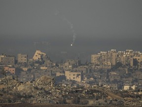 An Israeli army flare is seen over the Gaza Strip, as seen from southern Israel, Sunday, Dec. 3, 2023. Global Affairs Canada is announcing the death of an eighth Canadian citizen in the Israel-Hamas war.