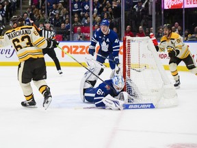 Boston Bruins left wing Brad Marchand (63) scores on Toronto Maple Leafs goaltender Joseph Woll (60) in overtime NHL hockey action, in Toronto on Saturday, Dec. 2, 2023.