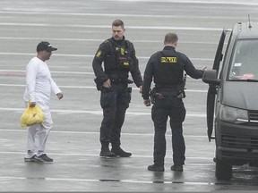 Danish police officers accompany financier Sanjay Shah as he arrives at Kastrup Airport, in Copenhagen, Wednesday, Dec. 6, 2023. Shah, a Dubai-based British hedge fund trader sought by Danish authorities for allegedly orchestrating a $1.7 billion tax fraud, considered one of the largest in the Scandinavian country, has been extradited from the United Arab Emirates, officials said Wednesday.