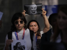 Activists participate in a demonstration with the image of jailed activist Mohamed al-Siddiq and Egyptian pro-democracy activist Alaa Abdel-Fattah at the COP28 U.N. Climate Summit, Saturday, Dec. 9, 2023, in Dubai, United Arab Emirates.
