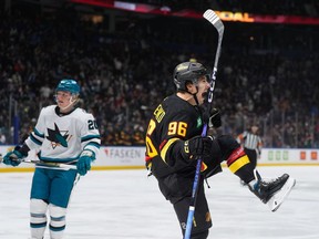 Vancouver Canucks' Andrei Kuzmenko (96) celebrates his first goal as San Jose Sharks' Fabian Zetterlund (20) looks on during the first period of an NHL hockey game in Vancouver, on Saturday, Dec. 23, 2023.