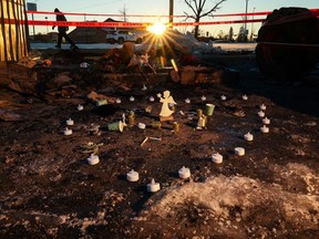 A memorial marks the scene of a fatal fire that killed three people as the sun rises on Tuesday, December 12, 2023. The three had been sleeping in a garden shed in the Lowe's parking lot in Crowfoot when the fire broke out early Monday morning.