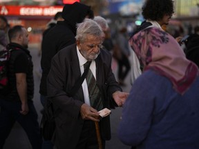A man purchases food from a street vendor at Kadikoy ferry terminal in Istanbul, Thursday, Nov. 16, 2023. Turkey's central bank delivered another huge interest rate hike on Thursday, Nov. 23, 2023 continuing its effort to curb double-digit inflation that has left households struggling to afford food and other basic goods.