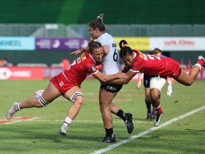 Canada's Krissy Scurfield, left, and Asia Hogan-Rochester, right, tackle New Zealand's Michaela Blyde at the Emirates Dubai 7s at the Sevens Stadium in Dubai in this Dec. 3, 2023 handout photo.