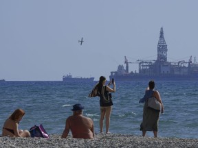 FILE - People on the beach take photos of the 'Tungsten Explored' drilling ship, in the southern coastal city of Larnaca, Cyprus, on Nov. 3, 2021. The Cyprus government and U.S. energy company Chevron have reached a deal on how to develop the Aphrodite gas field, the first to be discovered under the seafloor off Cyprus, an official said Friday, Dec. 1, 2023. The field is estimated to hold 4.2 trillion cubic feet of gas.