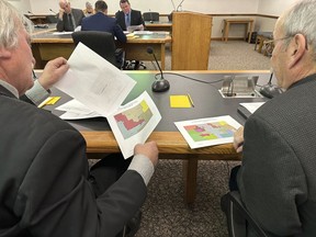 FILE - North Dakota state Rep. Robin Weisz, at left, and state Sen. Jerry Klein, both Republicans, inspect alternative maps proposed by the Turtle Mountain Band of Chippewa Indians and the Spirit Lake Tribe, on Tuesday, Dec. 5, 2023, during a meeting of a top legislative panel at the state Capitol in Bismarck, N.D. The 8th U.S. Circuit Court of Appeals denied a request on Friday, Dec. 15, to delay a federal judge's decision that North Dakota's legislative map violates the Voting Rights Act in diluting the voting strength of two Native American tribes.