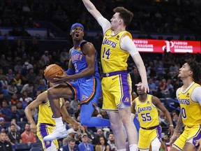 FILE - Oklahoma City Thunder guard Shai Gilgeous-Alexander (2) prepares to pass the ball away from Los Angeles Lakers center Colin Castleton (14) as Lakers guard Jalen Hood-Schifino, right, watches during the second half of an NBA basketball game Nov. 30, 2023, in Oklahoma City. Oklahoma City voters will decide Tuesday Dec. 12, 2023, whether to approve a 1% sales tax for six years to fund a new downtown arena for the NBA's Oklahoma Thunder.
