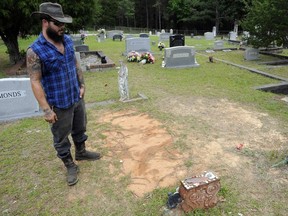 FILE - Tyler Goodson of the hit podcast "S-Town" stands at the grave in Green Pond, Ala., of his late friend John B. McLemore, who is also featured in the show, on May 3, 2017. Goodson, a man featured in the podcast which chronicled events in a rural Alabama community, died after being shot by police during a Sunday standoff, Dec. 3, 2023, a state agency said.