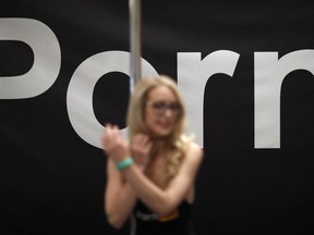 FILE - Porn actress Ginger Banks stands in the Pornhub booth during the AVN Adult Entertainment Expo, Wednesday, Jan. 24, 2018, in Las Vegas. The owner of Pornhub, one of the world's largest adult content websites, has admitted to profiting from sex trafficking and agreed to make payments to women whose videos were posted without their consent, federal prosecutors in New York announced Thursday, Dec. 21, 2023.