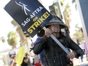 FILE - SAG-AFTRA member Bruce D. Mitchell participates in a post apocalyptic-themed picket line outside Netflix studios, Nov. 8, 2023, in Los Angeles. Hollywood's actors have voted to ratify the deal with studios that ended their strike after nearly four months, leaders announced Tuesday, Dec. 5, 2023.