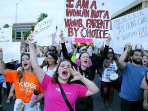 FILE - Protesters in Phoenix shout as they join thousands marching around the Arizona state Capitol after the U.S. Supreme Court decision to overturn the landmark Roe v. Wade abortion decision on June 24, 2022. Three state supreme courts are scheduled to hear arguments in abortion-related cases this week.