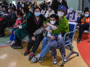 Parents wait with their children at a children's hospital in Beijing