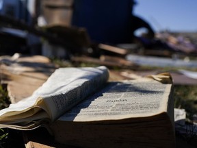 A Bible rests on the lawn of Community Baptist Church amongst storm debris Monday, Dec. 11, 2023, in Nashville, Tenn. The church was destroyed when severe storms came through over the weekend. Members of the church were trapped and injured inside the building during the storm on Saturday.