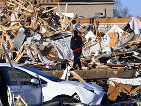 Amber Gardner looks at the debris from a friend's destroyed house in the West Creek Farms neighborhood on Sunday, Dec. 10, 2023, Clarksville, Tenn. Central Tennessee residents and emergency workers are continuing the cleanup from severe weekend storms.