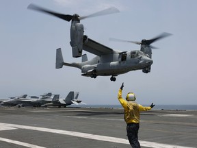 FILE -In this image provided by the U.S. Navy, Aviation Boatswain's Mate 2nd Class Nicholas Hawkins, signals an MV-22 Osprey to land on the flight deck of the USS Abraham Lincoln in the Arabian Sea on May 17, 2019. When the U.S. military took the extraordinary step of grounding its fleet of V-22 Ospreys this week, it wasn't reacting just to the recent deadly crash of the aircraft off the coast of Japan. The aircraft has had a long list of problems in its short history.