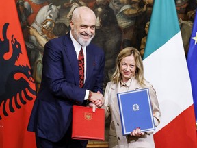 FILE - Italy's Premier Giorgia Meloni, right, and Albania's Prime Minister Edi Rama, left, shake hands after the signing of a memorandum of understanding on migrant management centers during a meeting in Rome, Italy, Monday, Nov. 6, 2023. Albania has agreed to host two migrant processing centers on its territory that will be run by Italy under a deal that worries human rights activists. The European Union, however, sees it as a possible future template.