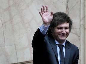 President-elect Javier Milei waves during a joint session of Congress to officially declare him and his running mate winners of the presidential runoff election, in Buenos Aires, Argentina, Wednesday, Nov. 29, 2023.