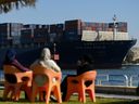 People watch as a ship transits the Suez Canal towards the Red Sea on Jan. 10, 2024 in Ismailia, Egypt. In the wake of Israel's war on Gaza after the Oct. 7 Hamas attack on Israel, Houthi rebels in Yemen pledged disruption on all ships destined for Israel through the Red Sea's Suez Canal. 