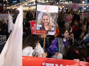 People raise a placard bearing a picture of Israeli hostage Romi Gonen