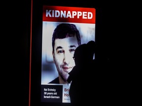 A pedestrian is silhouetted against a digital poster on Toronto’s Bloor Street West showing Israeli hostage Itai Svirsky taken by Hamas terrorists during the Israel Hamas war, Thursday January 11, 2024.