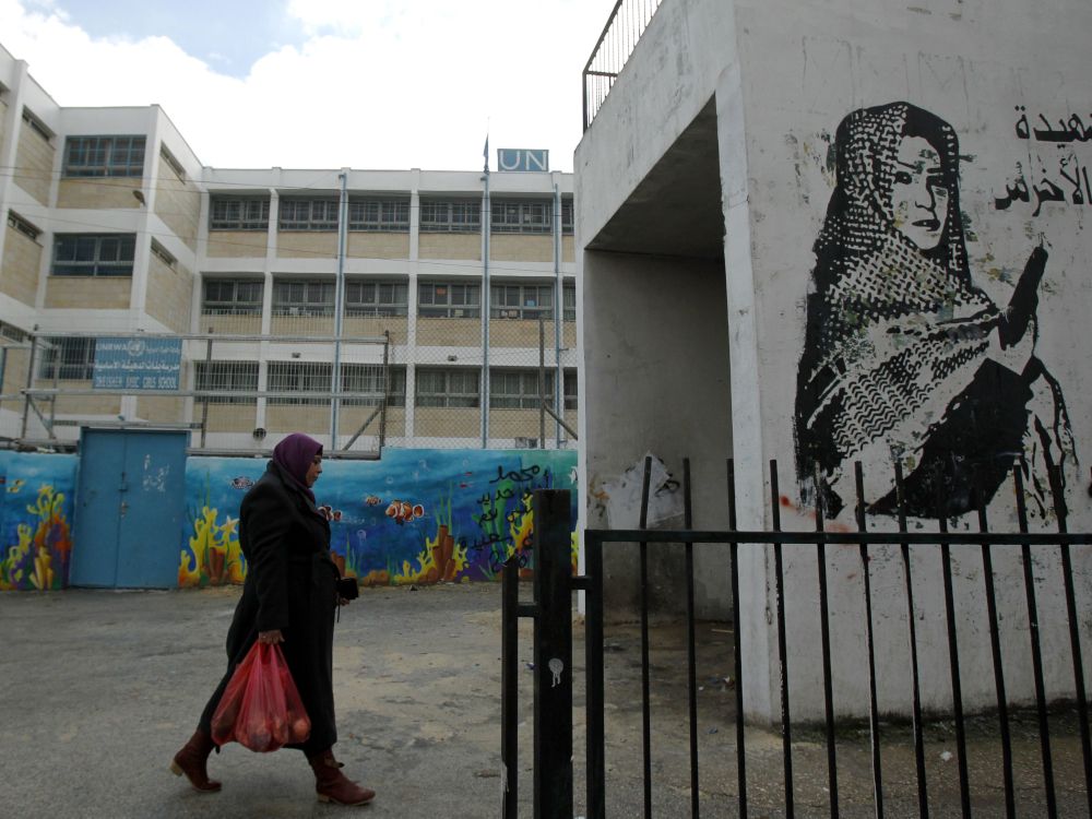 A Palestinian woman walks outside of a United Nations school near Bethlehem, in 2018.