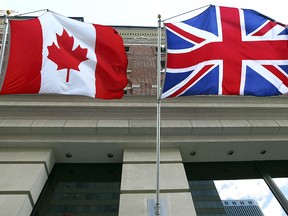 A Canadian flag flies alongside a British flag.