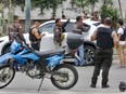 Police inspect a car after a fatal shooting.