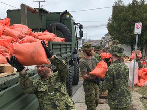 Soldiers fill sandbags to fight off extensive flooding in Gatineau, Que., on April 24, 2019.