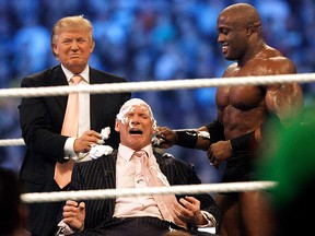 Donald Trump (left) and ECW World Champion Bobby Lashley shave the head of Vince McMahon.