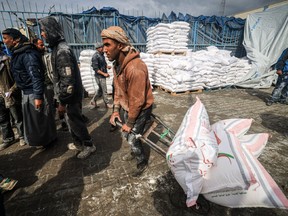 Displaced Palestinians receive food aid in Gaza.